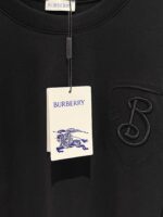 Maglietta nera Burberry con logo ricamato e etichetta con cavaliere, stile elegante e casual.