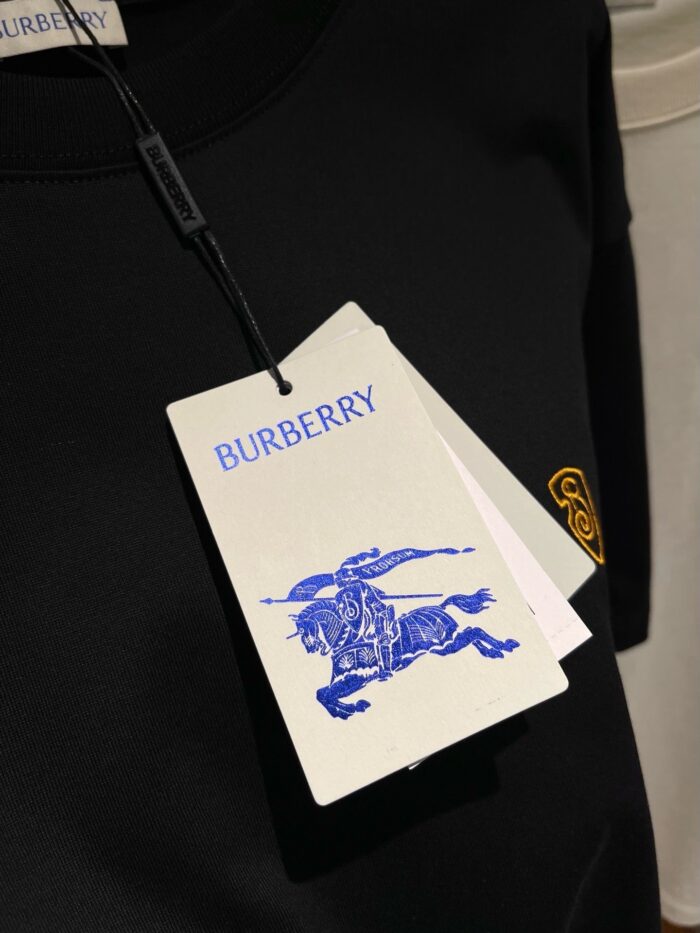 Felpa nera Burberry con logo giallo, dettagli eleganti e etichette di alta qualità.
