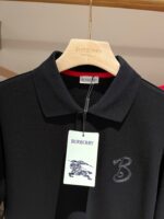 Polo nera Burberry con logo ricamato, tessuto di alta qualità e stile elegante.
