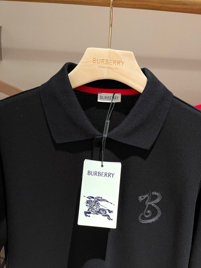 Polo nera Burberry con logo ricamato, tessuto di alta qualità e stile elegante.