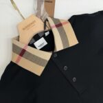 Polo nera Burberry con colletto check iconico, stile elegante e tessuto di alta qualità.
