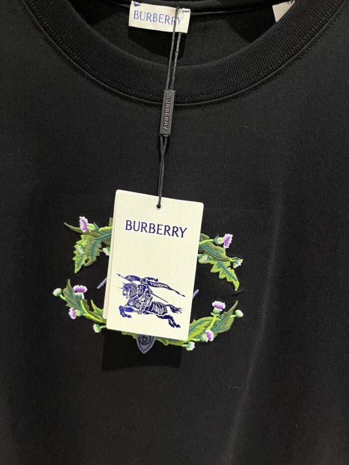 Maglietta nera Burberry con ricamo equestre, dettagli eleganti e logo di lusso.