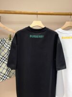 Magliette Burberry nera e bianca con logo colorato su esposizione elegante.