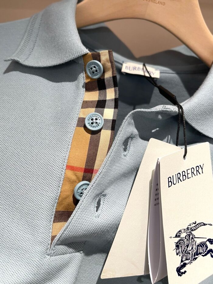 Maglietta polo blu Burberry con colletto check, dettagli eleganti e alta qualità in cotone.