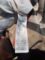 Etichetta Burberry di alta qualità su tessuto a quadri, dettagli e cura del capo.