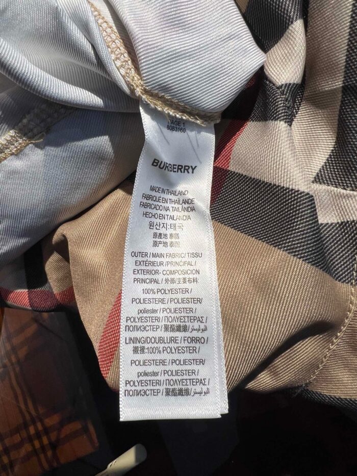 Etichetta Burberry di alta qualità su tessuto a quadri, dettagli e cura del capo.