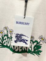 Etichetta Burberry con logo cavallo, fiori floreali e dettagli eleganti in stile lusso.