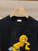 T-shirt Burberry con ape sorridente e orologio, stile moderno e divertente in cotone morbido.