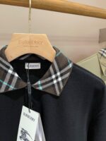 Camicia Burberry nera con colletto check, sull’gancio di lusso con logo impresso.