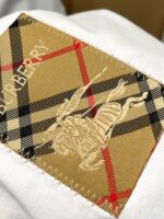 Patch Burberry con logo cavaliere e motivo check classico beige, nero, rosso e bianco.