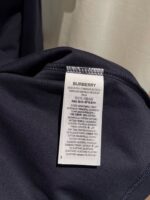 Etichetta Burberry con istruzioni di cura su abbigliamento nero di alta qualità.