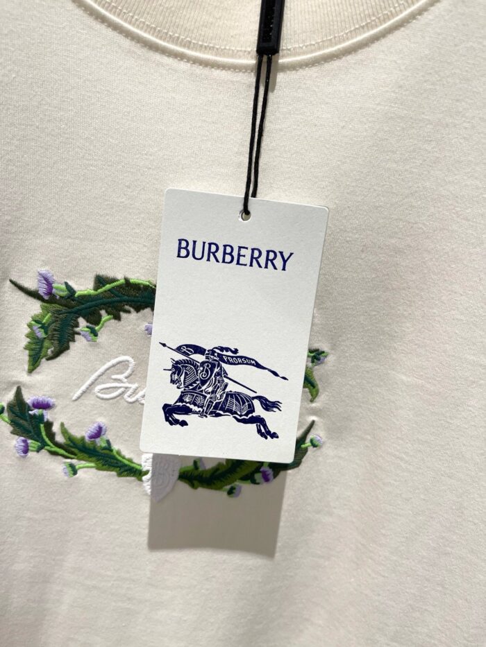 Etichetta Burberry con logo, dettagli floreali e design elegante su giacca o t-shirt.