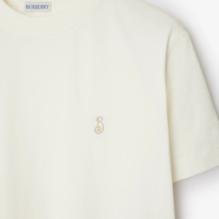 Maglietta donna Burberry crema con logo ricamato, stile minimalista e tessuto di alta qualità.
