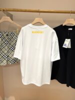 Esposizione di abbigliamento Burberry: T-shirt bianca, shorts check e maglietta nera elegante.