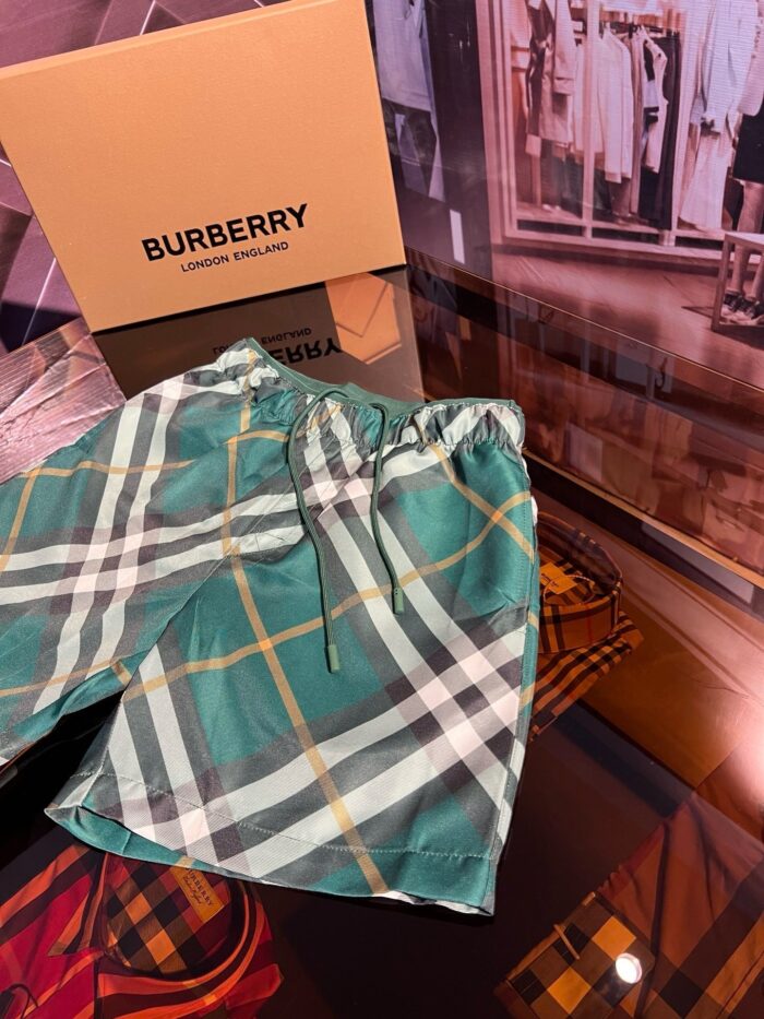 Pantaloncini Burberry verdi con fantasia check, eleganti e di lusso, in esposizione raffinata.