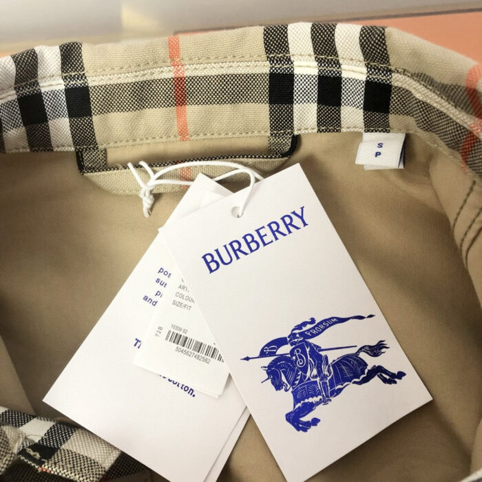 Interno giacca Burberry con motivo check, logo blu e etichette di qualità.