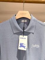 Poloshirt Burberry uomo blu chiaro in tessuto di qualità, logo elegante, stile casual e raffinato.