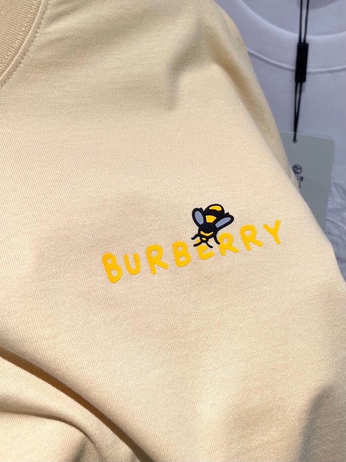 Maglione Burberry con logo giallo e disegno di ape giocosa, stile moderno e accattivante.