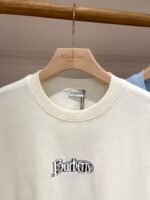 Felpa Burberry beige con logo ricamato, stile casual e lusso, su stampo di legno.