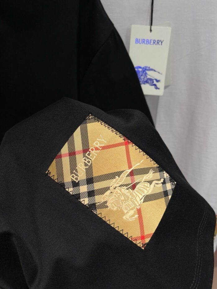 Giacca Burberry nero con patch check iconico e stemma cavaliere, stile elegante e di lusso.