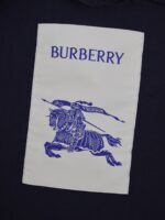 Etichetta Burberry con logo cavaliere e dettagli eleganti, simbolo di lusso e tradizione britannica.