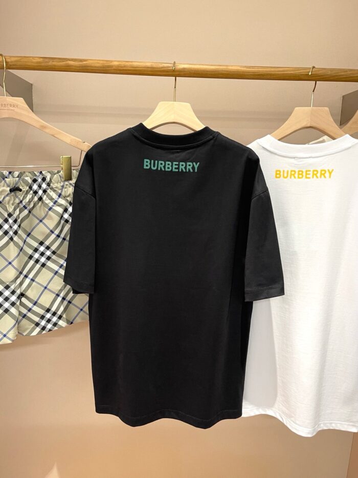 Esposizione minimalista di capi Burberry con magliette colorate e pantaloncini a quadri.