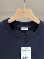 Felpa navy blue Burberry su appendiabiti di legno con etichetta e logo cavallo.