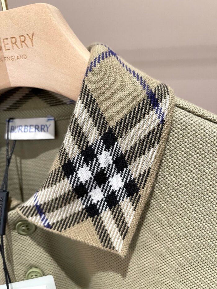 Polo Burberry beige con colletto tartan iconico, tessuto di alta qualità, stile elegante e versatile.