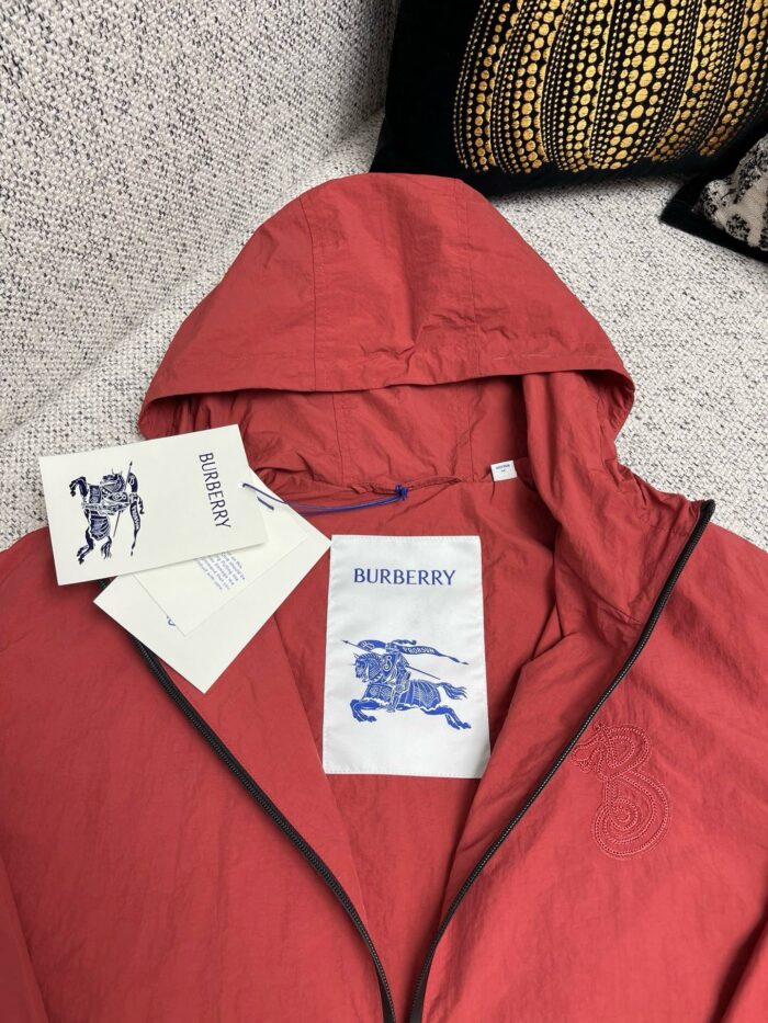 Giacca rossa Burberry moderna con etichette di lusso, stile elegante e vibrante.