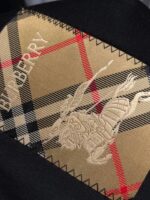 Cravatta Burberry nera con motivo tartan, emblema equestre ricamato, logo bianco elegante.