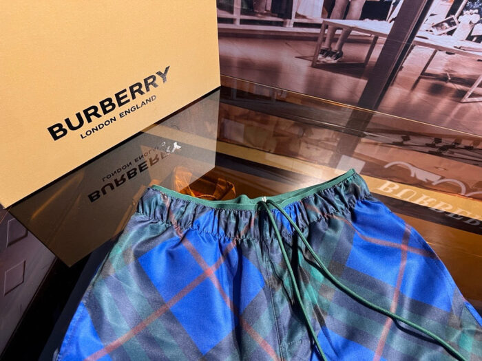Shorts da spiaggia Burberry tartan colorato, stile luxury, perfetti per estate e relax.