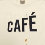 T-shirt vintage con stampa “Café”, imperfezioni stilose, marca GALLERY DEPT., look casual e moderno.