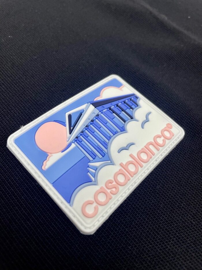 Badge colorato ispirato a Casablanca con architettura, nuvole e atmosfera nostalgica e moderna.