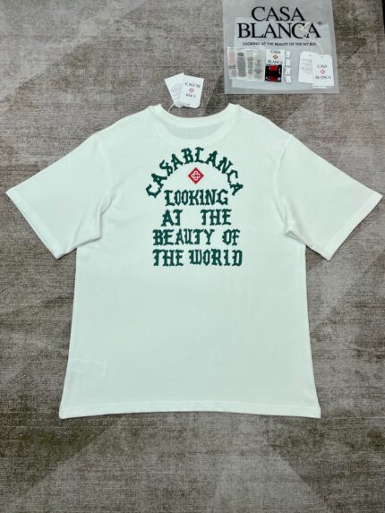 T-shirt Casa Blanca bianco con grafica e messaggio verde, stile casual e moderno.