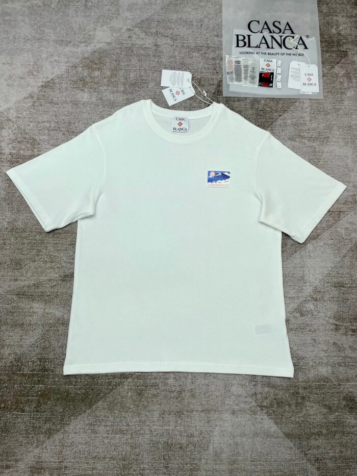 T-shirt bianca Casa Blanca con logo blu, stile casual e moderno, perfetta per ogni occasione.
