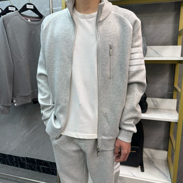 Look athleisure uomo grigio casual e sportivo con giacca e pantaloni comodi.