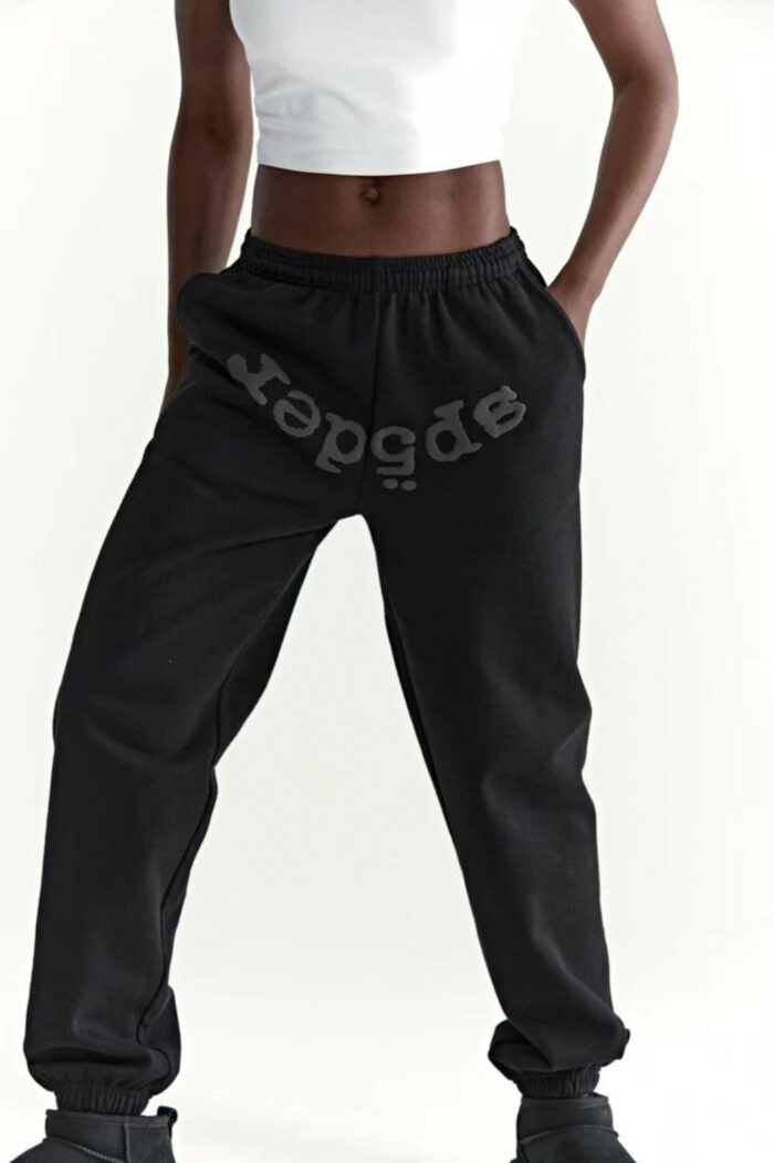 Look athleisure casual con pantaloni neri, crop top bianco e sneakers sportive.