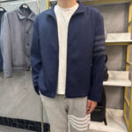 Stiloso outfit casual con giacca navy, t-shirt bianco e sweatpants grigi con righe biane.