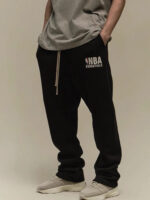 Look casual sportivo con T-shirt grigia, pantaloni NBA e sneakers leggere, stile confortevole e alla moda.