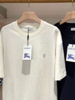 T-shirt casual crema e navy in stile minimalista, perfette per un look moderno e versatile.