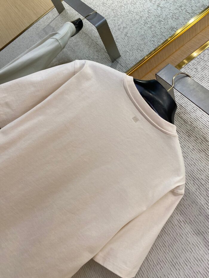 Maglietta beige casual su appendiabiti elegante, stile moderno e comfort minimalista.