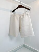 Pantaloncini bianchi casual su appendino in ambiente minimalista e moderno.