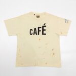 T-shirt beige con stampa Café e stile vintage, dettaglio di macchie autentiche.