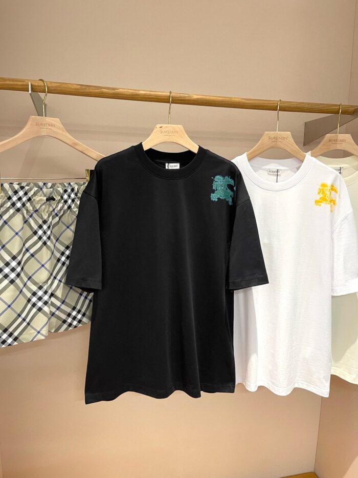 T-shirt casual nero e bianco con ricami colorati, stile giovane e versatile, in negozio elegante.