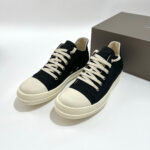 Sneakers nere con punta bianca, lacci crema, stile moderno e versatile per ogni look casual.