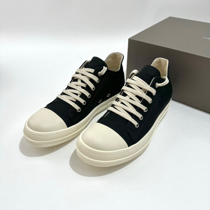 Sneakers nere con punta bianca, lacci crema, stile moderno e versatile per ogni look casual.