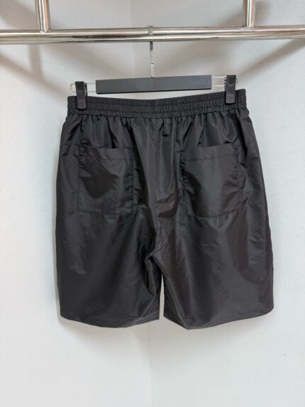 Pantaloncini neri sportivi con elastico, coulisse e tasche, ideali per fitness e relax.