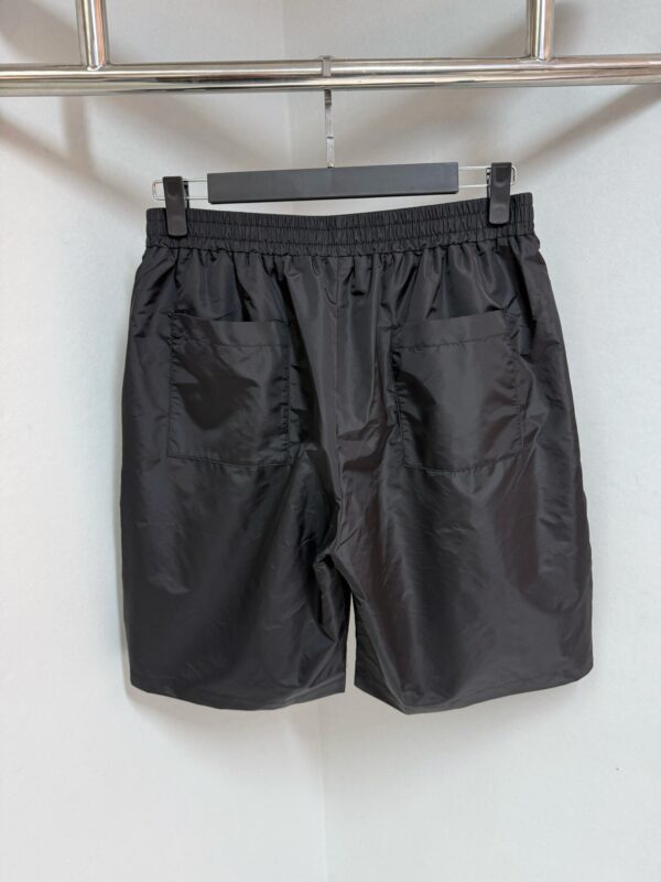 Pantaloncini neri sportivi con elastico, coulisse e tasche, ideali per fitness e relax.