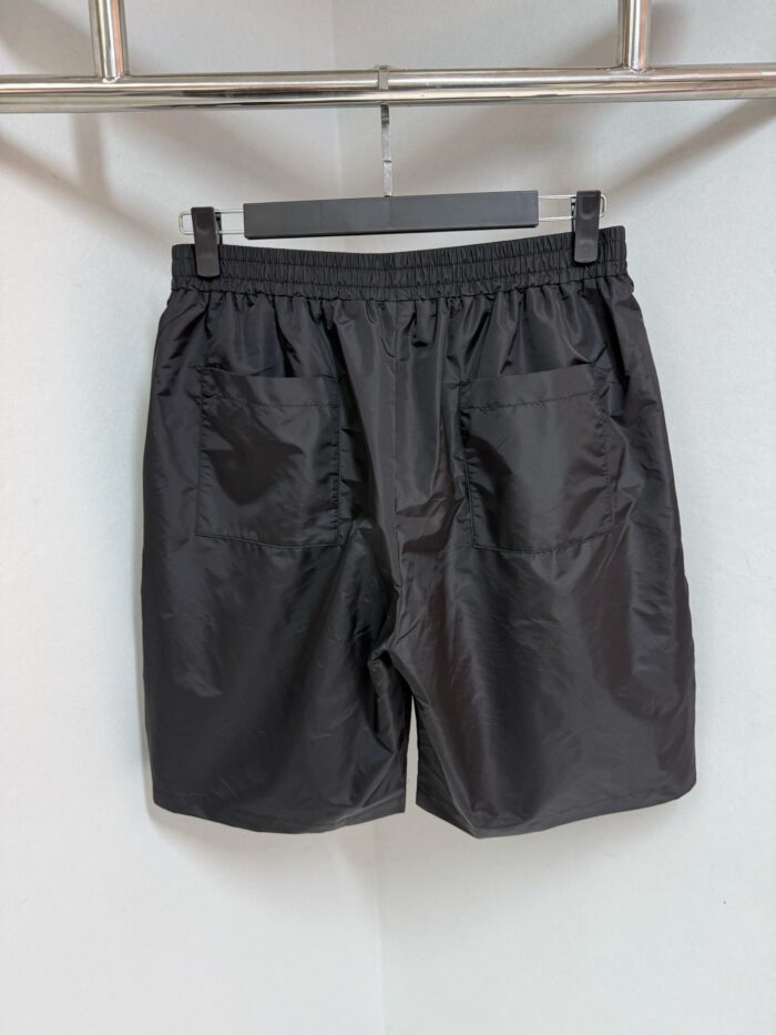 Pantaloncini neri sportivi con elastico, coulisse e tasche, ideali per fitness e relax.