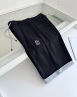 Pantaloni jogger neri con dettaglio grigio alle caviglie e logo minimalista sul fianco.